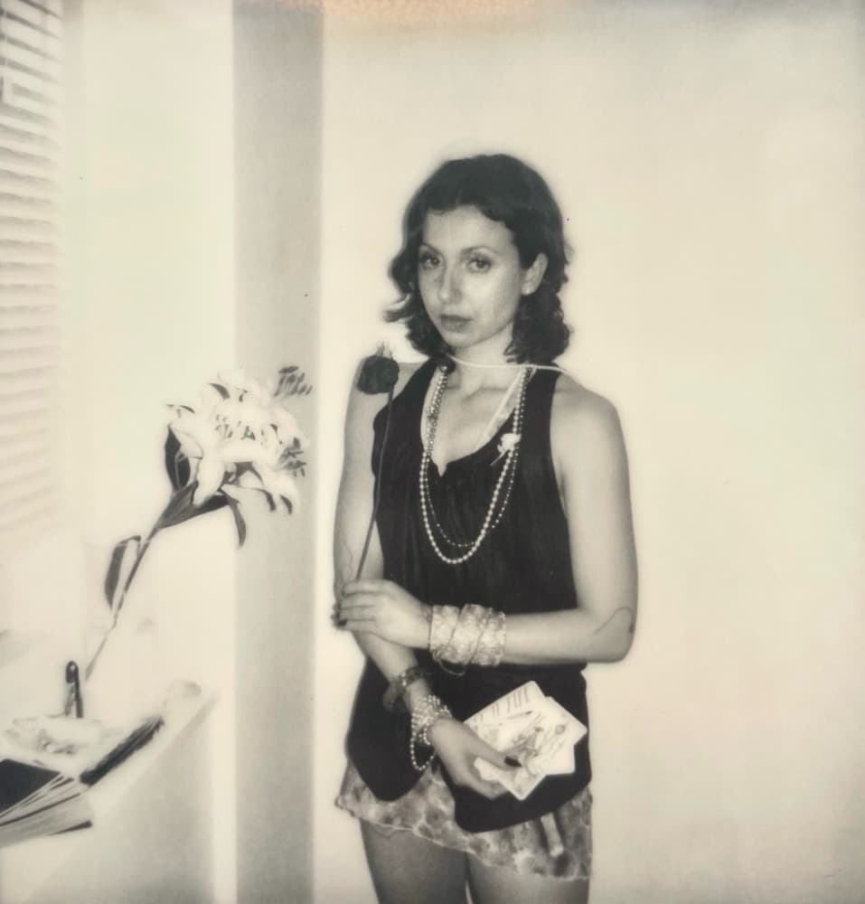 Ro holding a rose and tarot cards